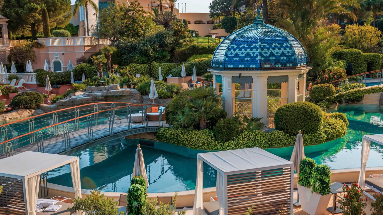 Basen hotelowy z białą altanką z niebieskim dachem