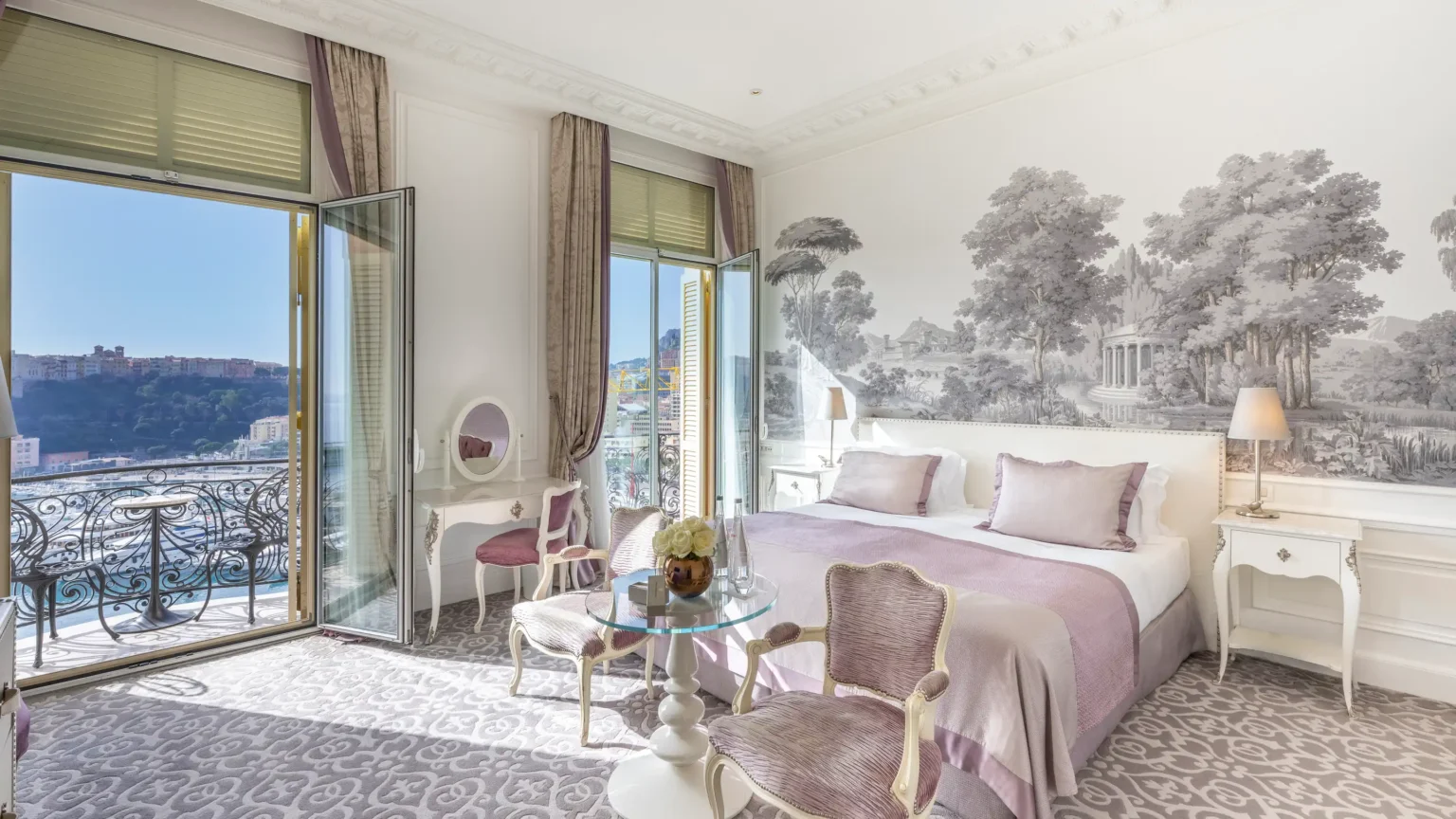 widok na pokój hotelowy z dużymi dwoma oknami, namalowanym lasem na ścianie za łóżkiem