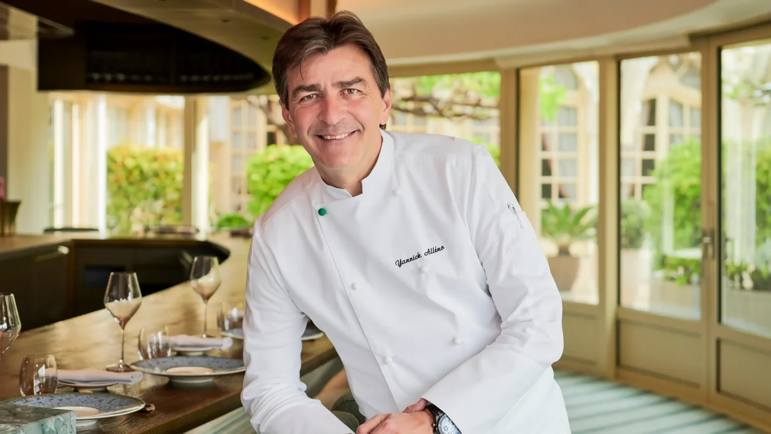 mężczyzna w kuchennym fartuchu opierający się o stół