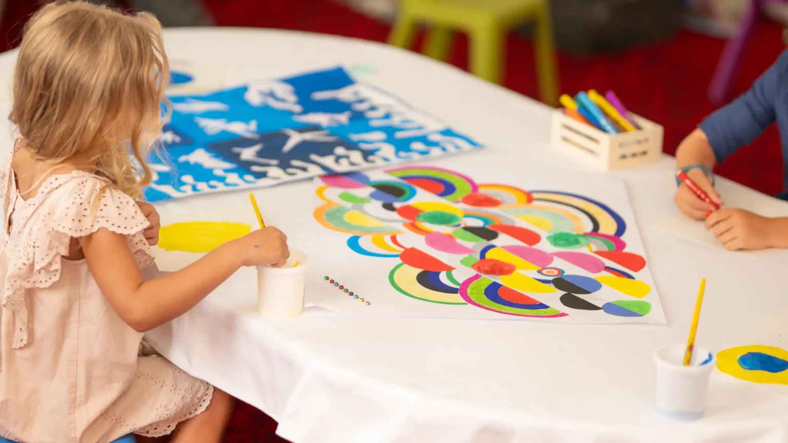 dzieci malujące farbami przy stole