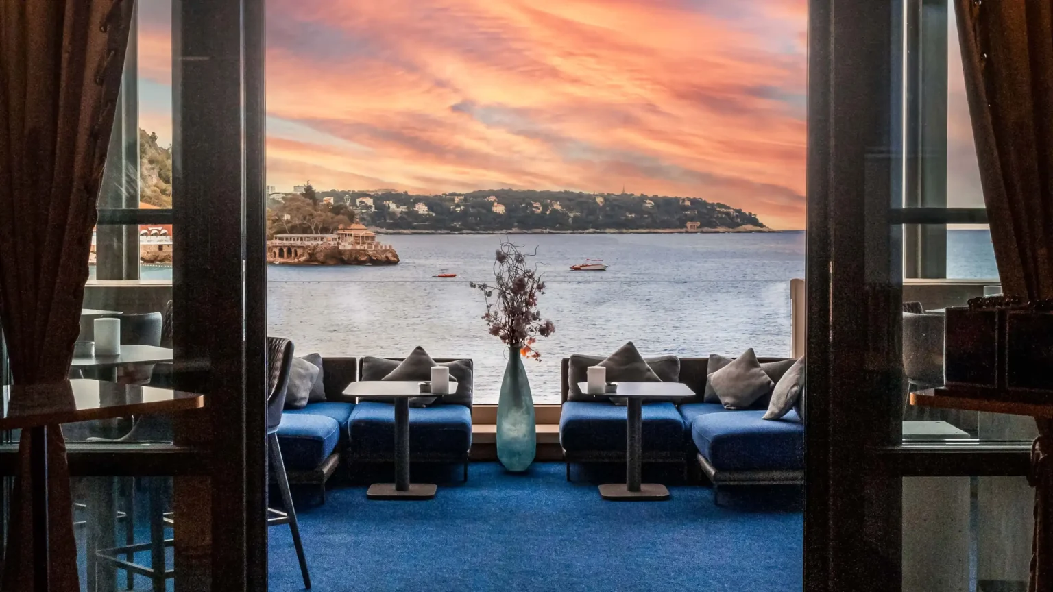 zachód słońca i taras hotelowy z brązowymi meblami