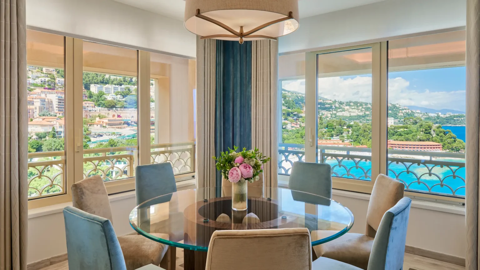 szklany stół jadalniany w otoczeniu błękitnych krzeseł