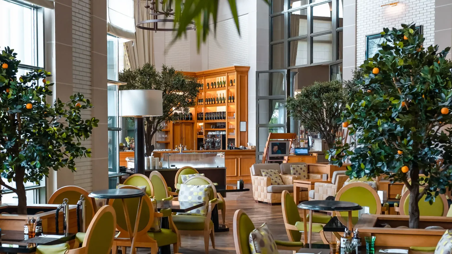 restauracja z brązowymi meblami w otoczeniu zieleni