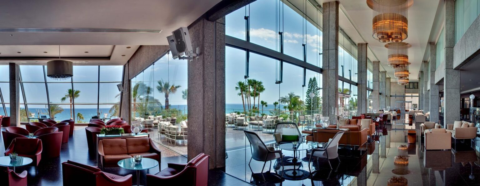 lobby i bar hotelowy z dużymi oknami - widok na morze i zieleń Amathus Beach Hotel