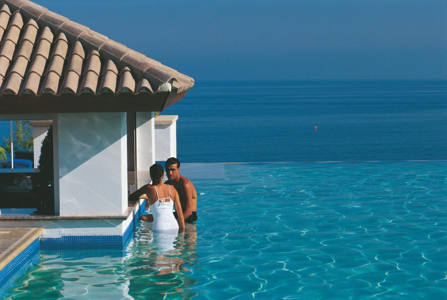 basen zewnętrzny z widokiem na morze, dwoje ludzi pływających w basenie