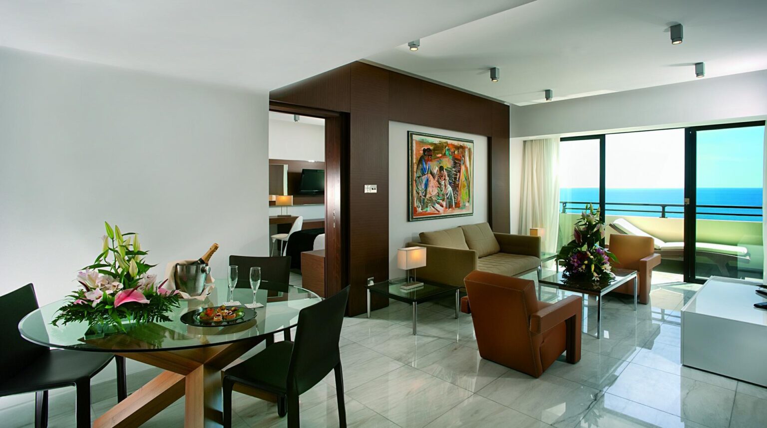 przykładowy pokój gościnny w apartamencie Amathus Beach Hotel, brązowe meble, jasna podłoga