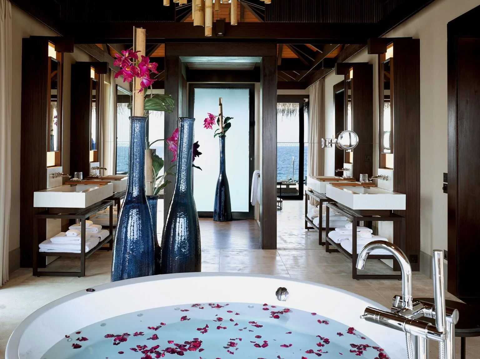 round white bathtub with rose petals overlooking the sea