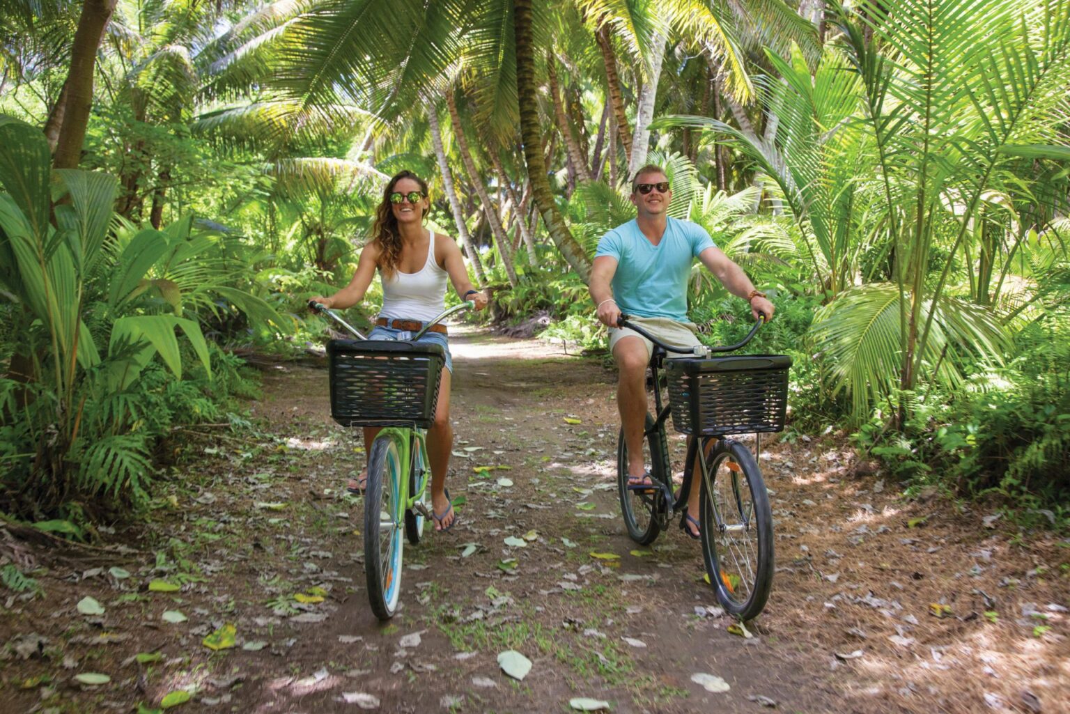 kobieta i mężczyzna na rowerach z koszykami przemierzający dżunglę