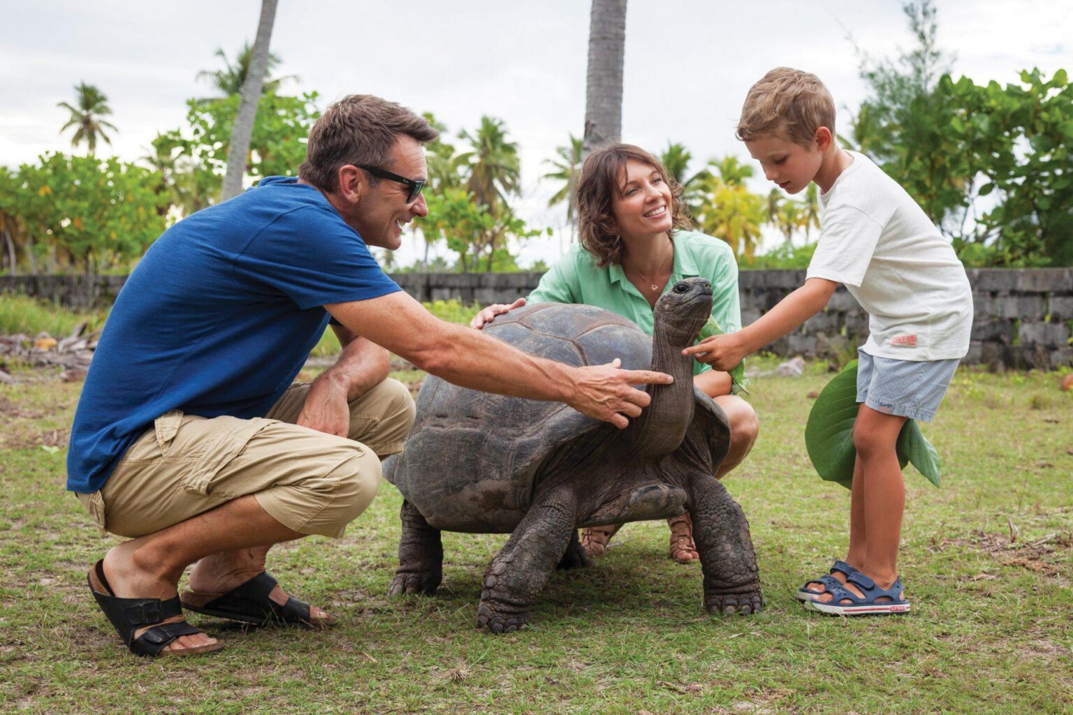 mężczyzna kobieta i dziecko stoją obok żółwia