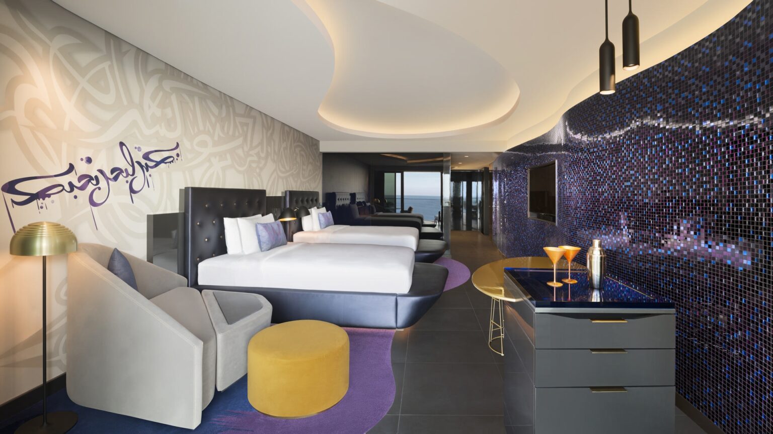 duza sypialnia z mozliwoscia sterowania swiatlem kolory dywanow sa konrastowe w fioletowym kolorze a dodatki zolte lub zielone