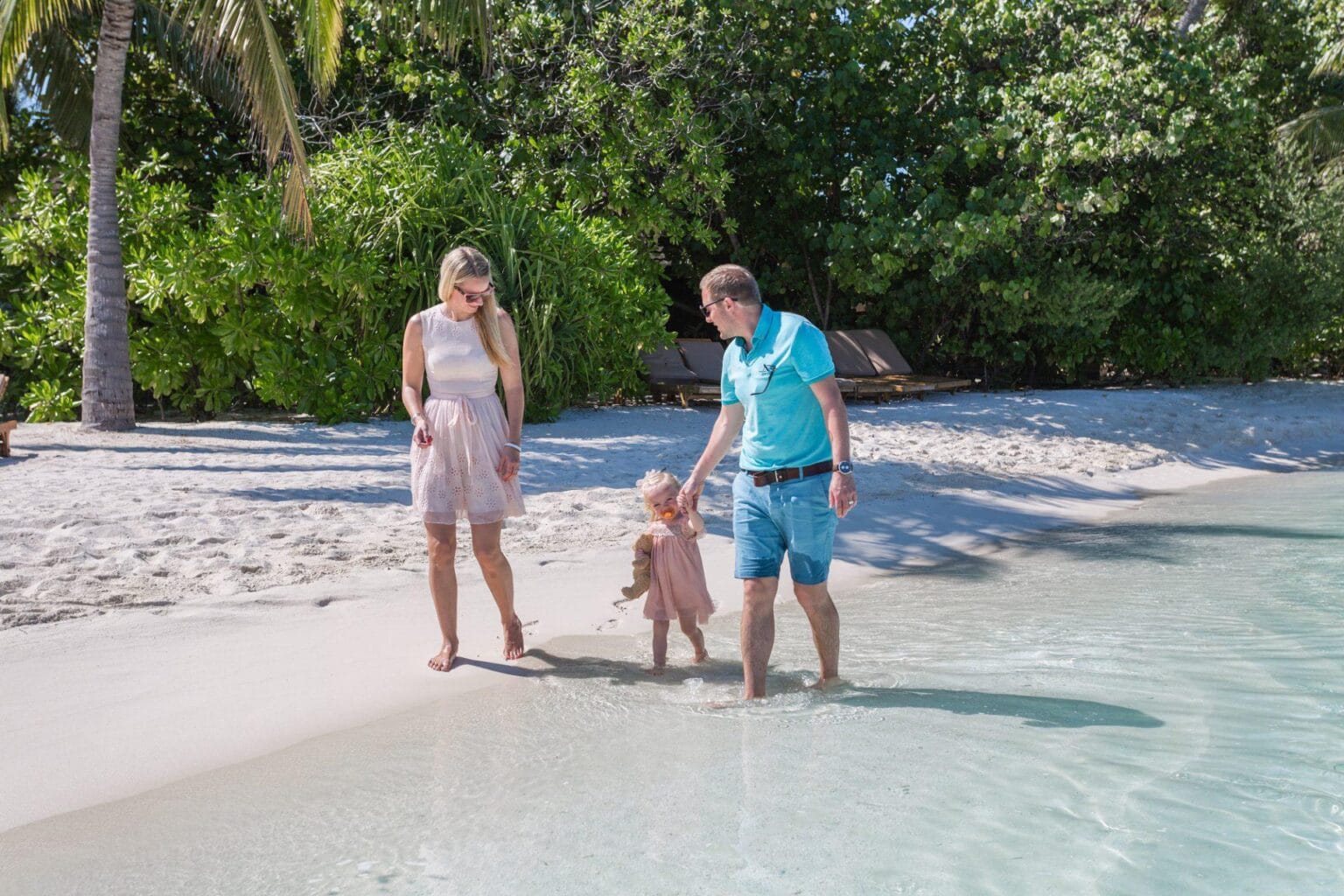 rodzice z dzieckiem spacerują po plaży Lily Beach Resort and Spa