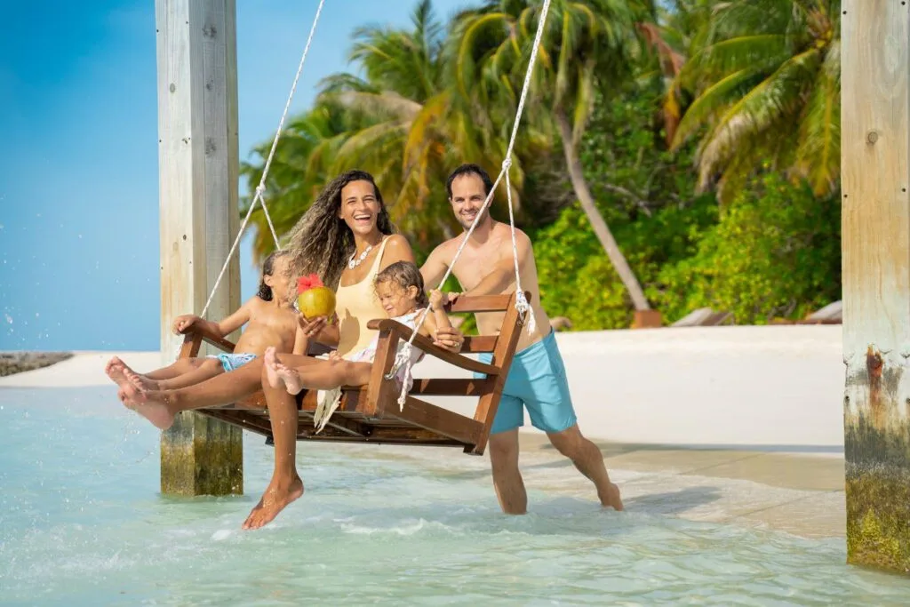 rodzina odpoczywająca na huśtawkach przy plaży na wodzie