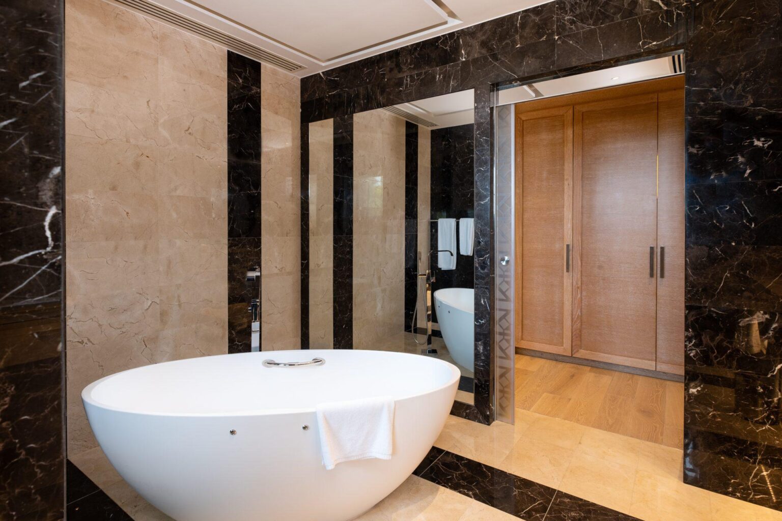 duża biała wanna po środku łazienki w Parklane, a Luxury Collection Resort & Spa