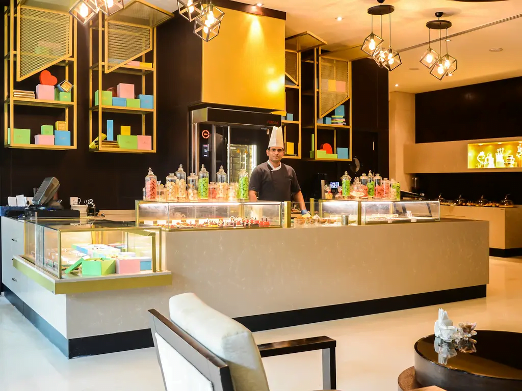 widok na bar hotelowy w jasnych barwach, cieple swiatlo i drewiane wykonczenia w Rixos The Palm Hotel & Suites - Ultra All-inclusive