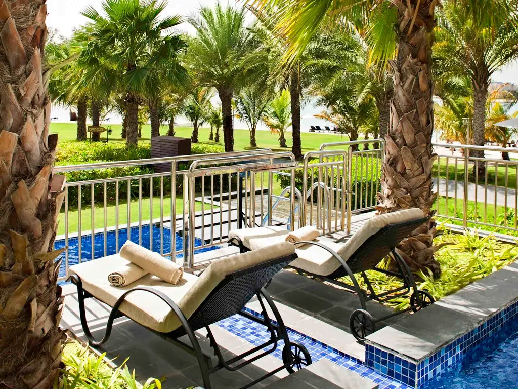 dwa leżaki wsrod palm - prywatny taras i basen w Rixos The Palm Hotel & Suites - Ultra All-inclusive