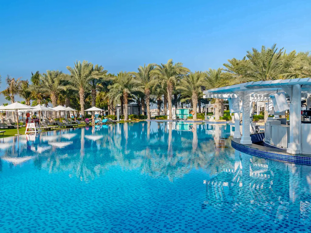 basen zewnętrzny otoczony palmami w Rixos The Palm Hotel & Suites - Ultra All-inclusive
