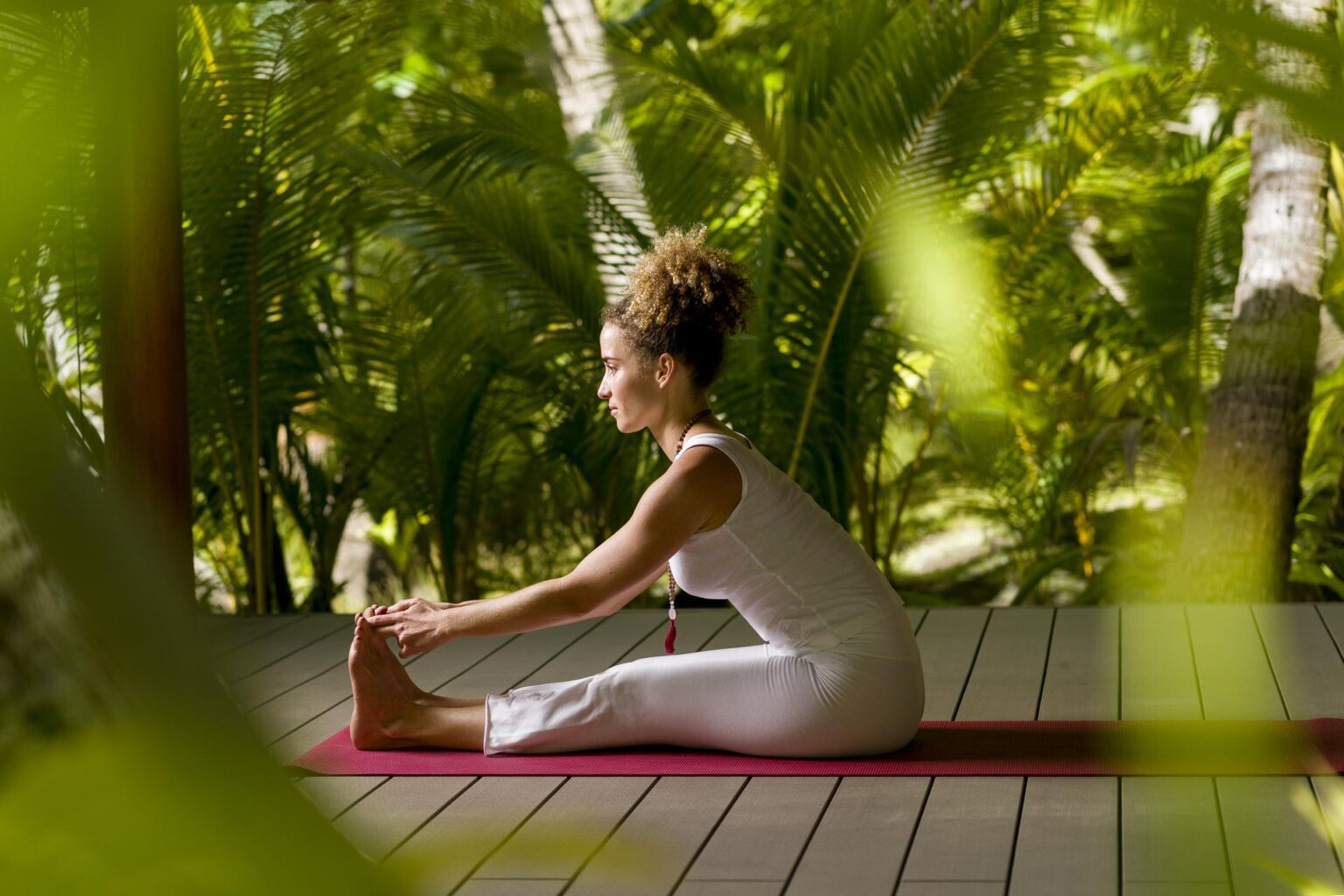 kobieta wykonująca jogę na macie do ćwiczeń na tle dżungli