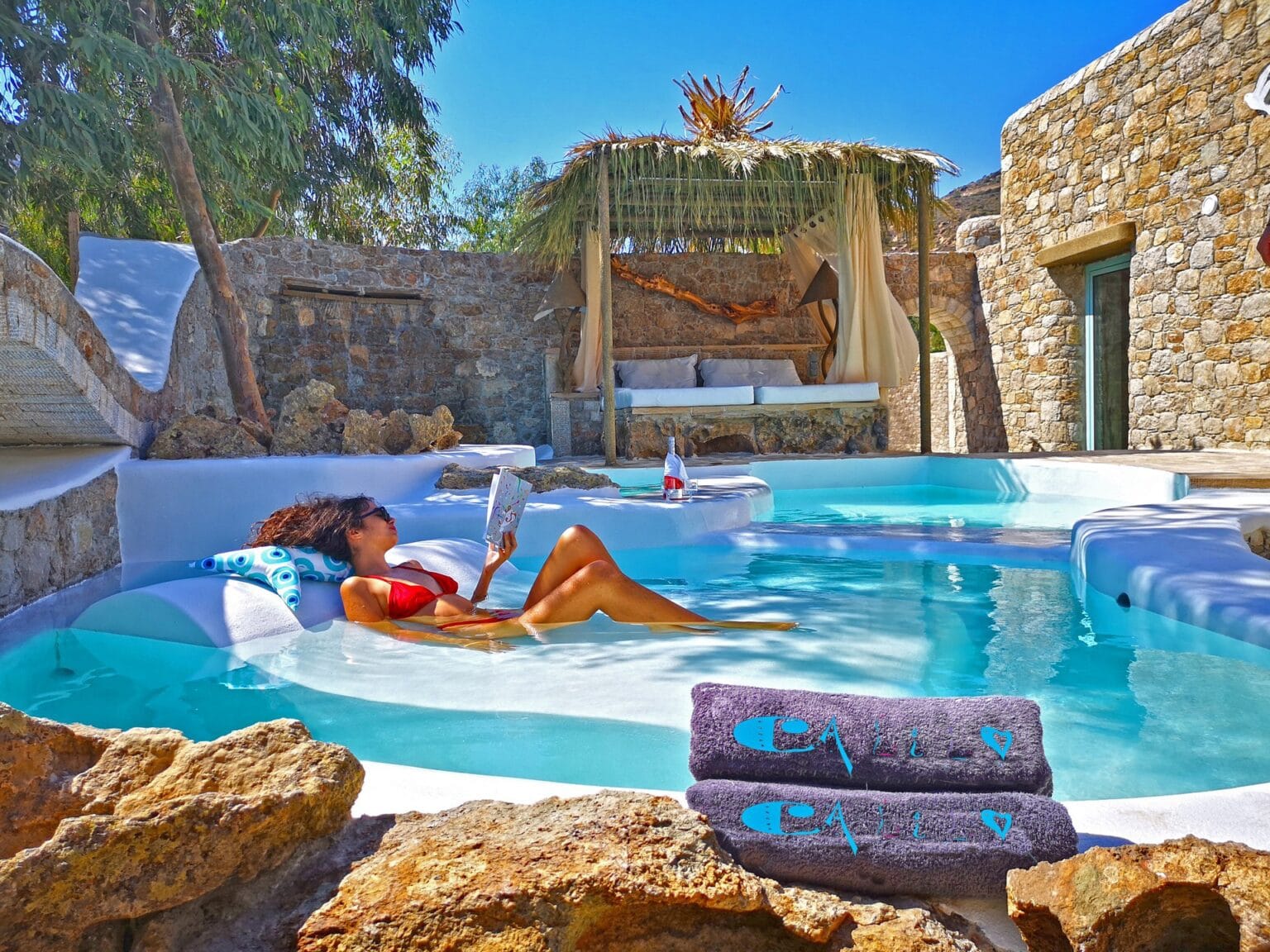 Calilo, Papas Beach, Ios Island kobieta wygrzewa się na słońcu w basenie zewnętrznym hotelu