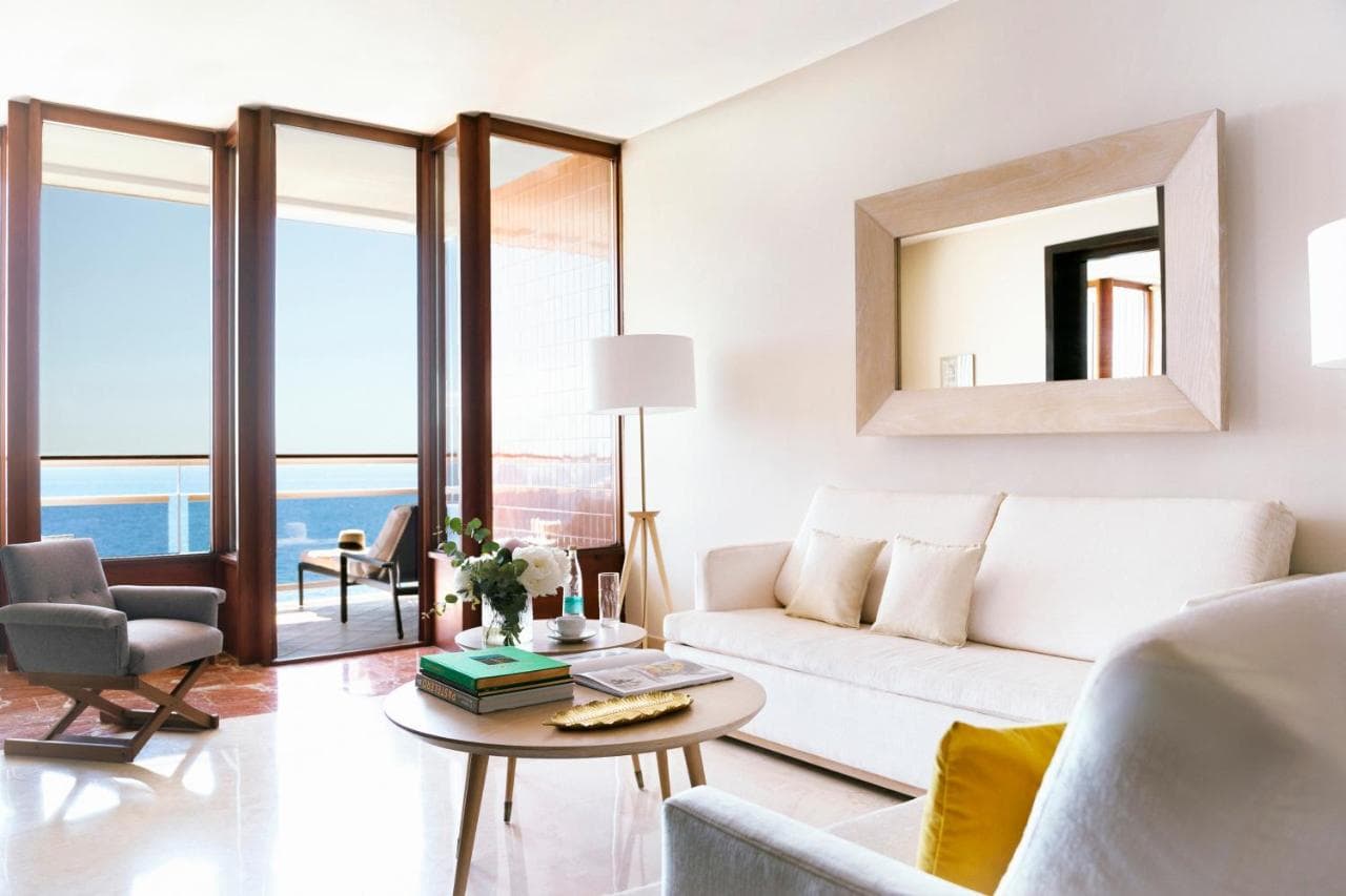 jasny salon z beżową kanapą i stolikiem kawowym z widokiem na ocean