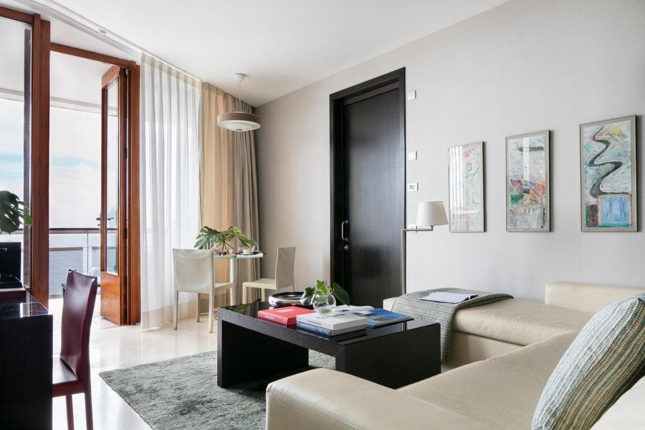 pokój w hotelu, czarne drzwi i stół oraz jasna kanapa