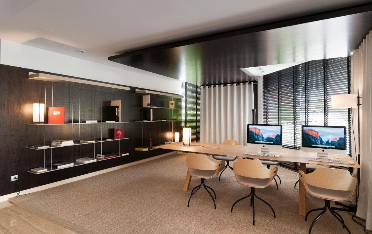 industrialne lobby hotelowe, z brązowymi krzesłami i monitorami na biurkach