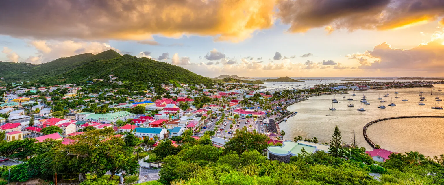 На фото панорама міста над затокою в сонячний день.