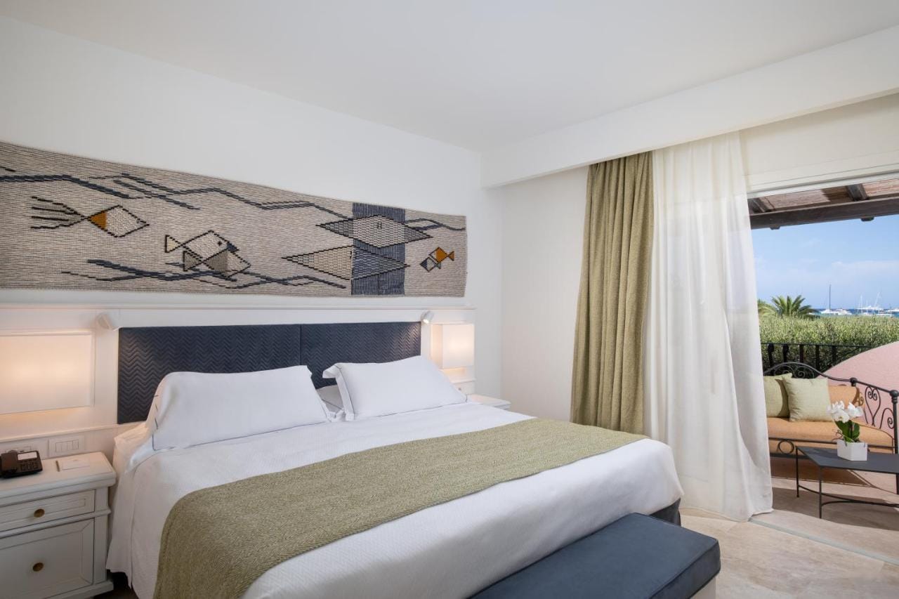 Przykładowy pokój - Hotel Abi d'Oru, Porto Rotondo: kolory biało beżowe, z widokiem na ocean i przyrodę.