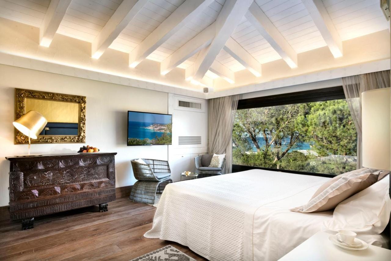 Przykładowy pokój - Hotel Abi d'Oru, Porto Rotondo: kolory biało beżowe, z widokiem na ocean i przyrodę.