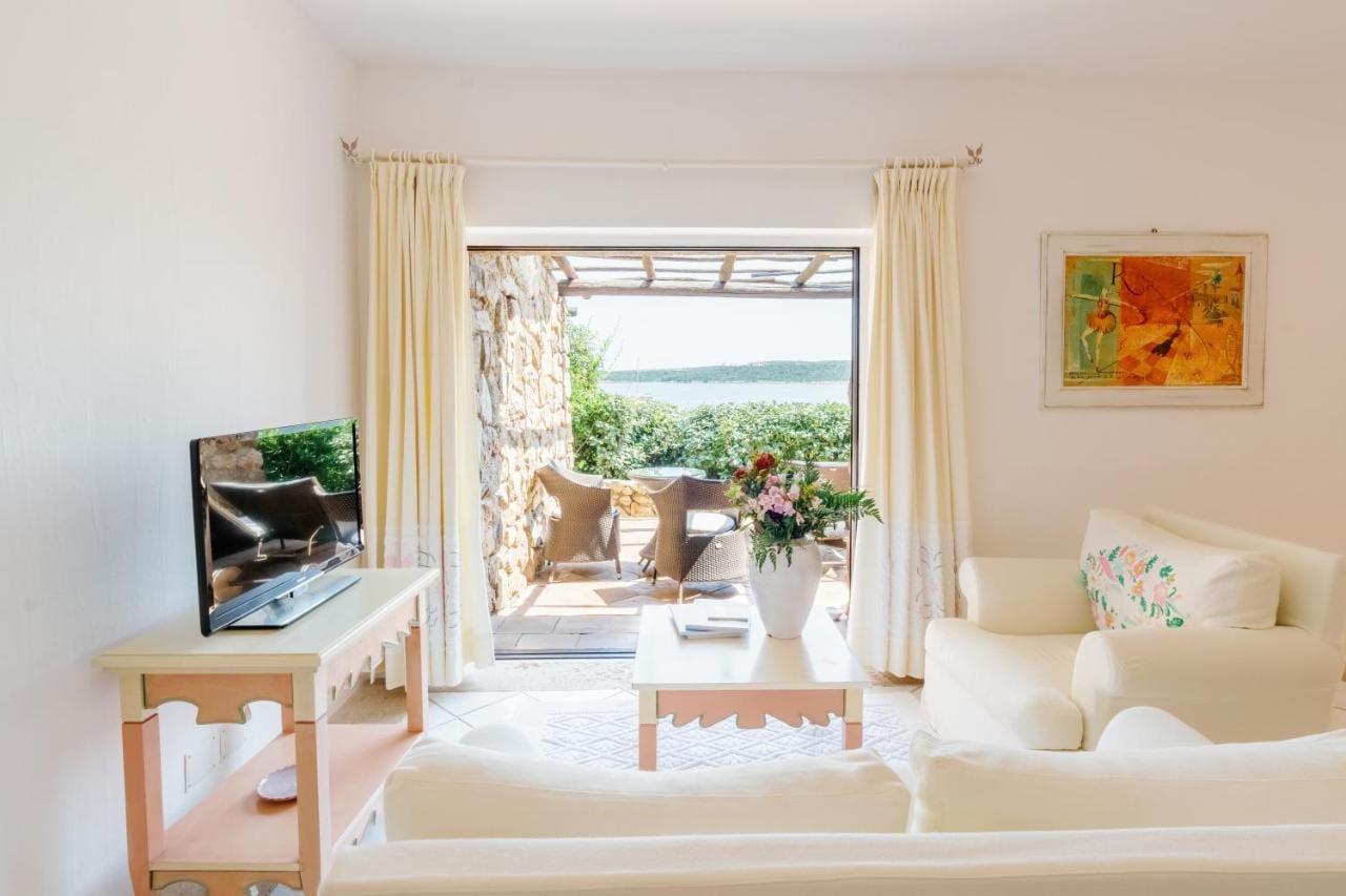 Salon w jasnym, beżowym kolorze w Hotel Pitrizza z widokiem na wodę