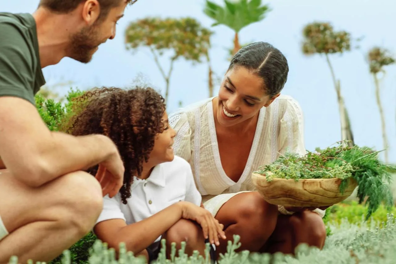 Szczęśliwa rodzina spędzająca czas zbieraniu roślin przy ogrodach hotelu Ikos Odisia