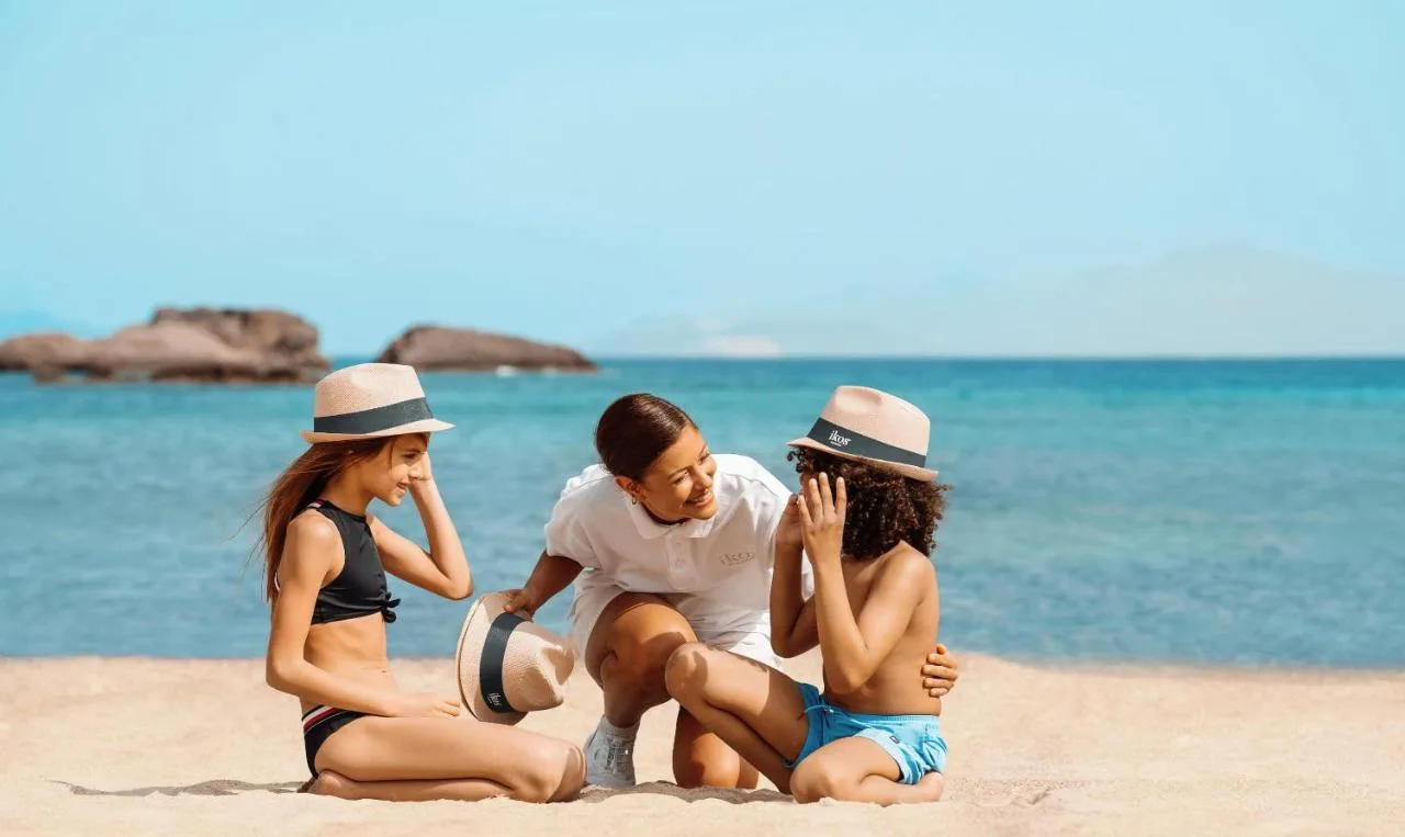 Dwójka szczęsliwych dzieci biorących udział w aktywnej zabawie na plaży w Ikos Odisia