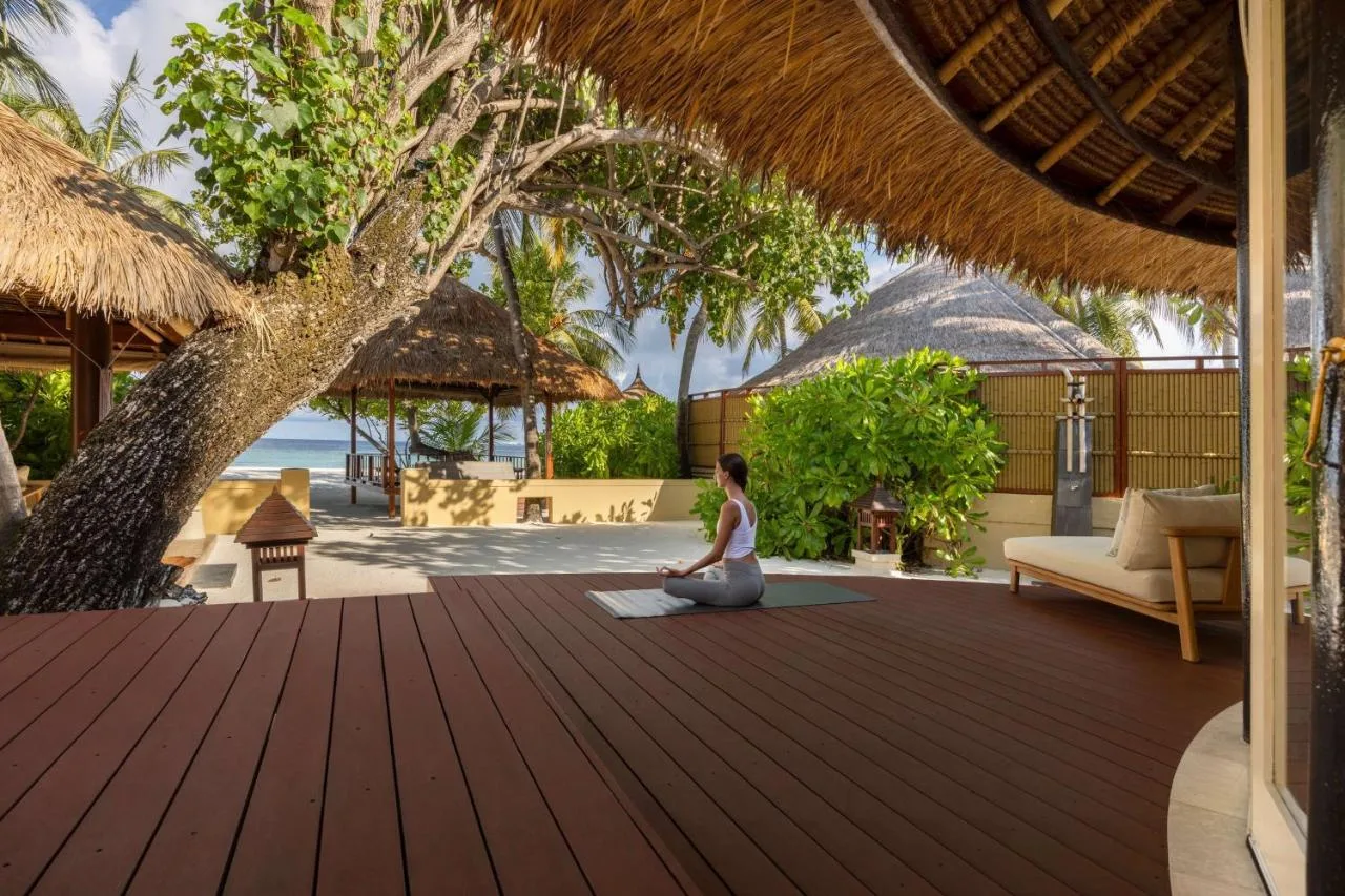 woman meditating in green surroundings near the beach on a brown terrace