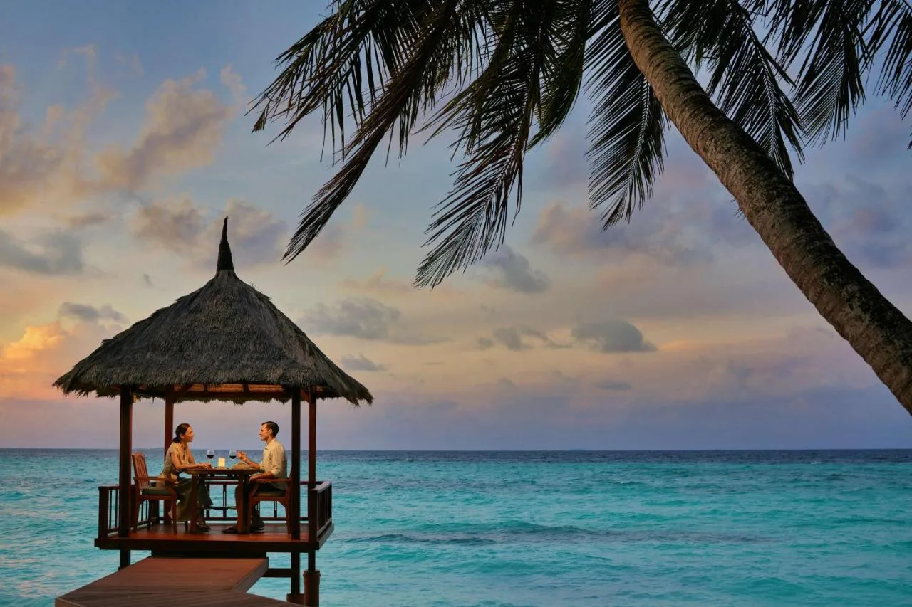 Couple relaxing on private terrace having dinner overlooking ocean banyan tree vabbinfaru