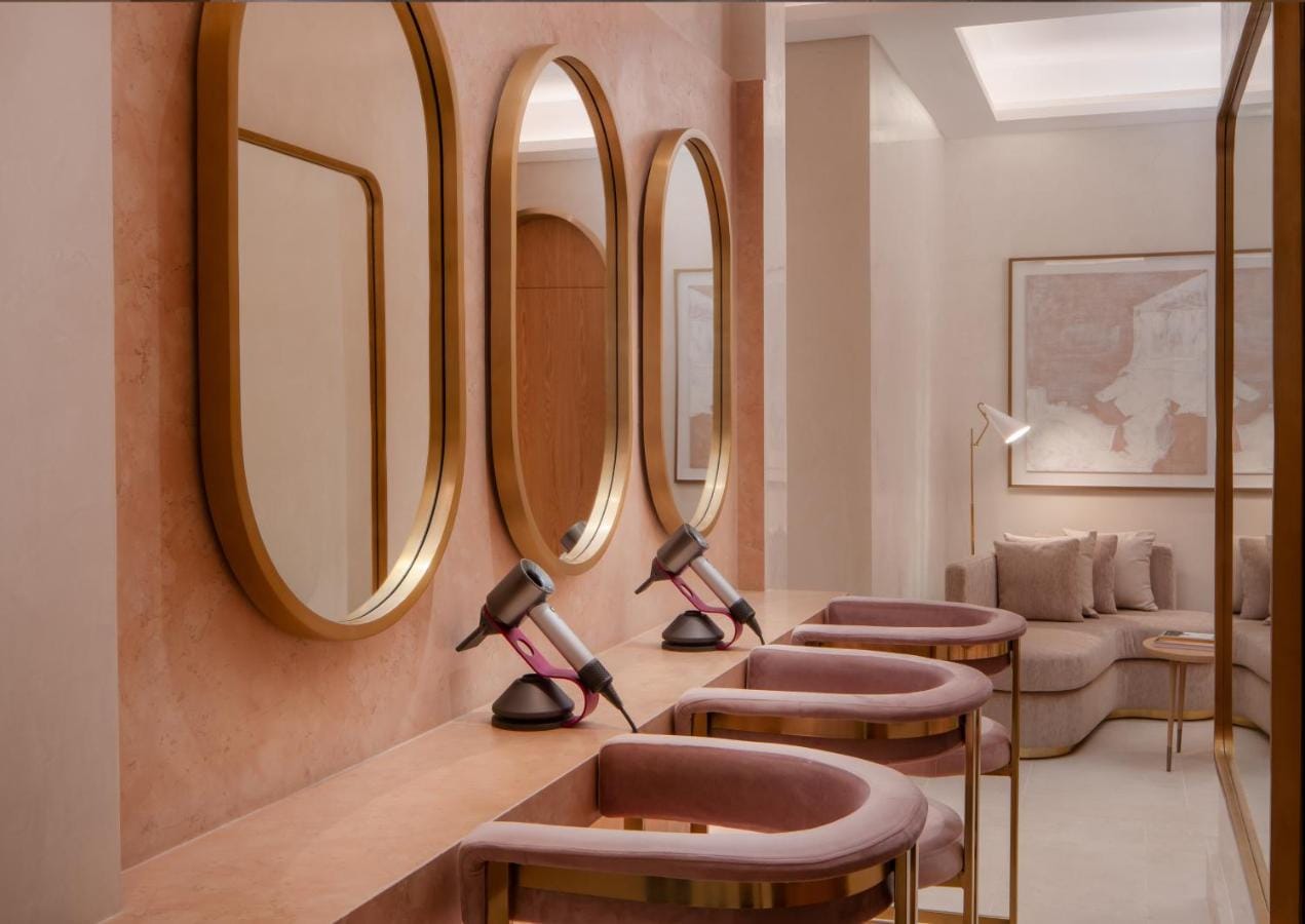 miejsce na skorzystanie z suszarek po korzystaniu ze strefy wellness, pozłacane lustra, suszarki do włosów i różowe fotele w four seasons resort and residences at the pearl qatar