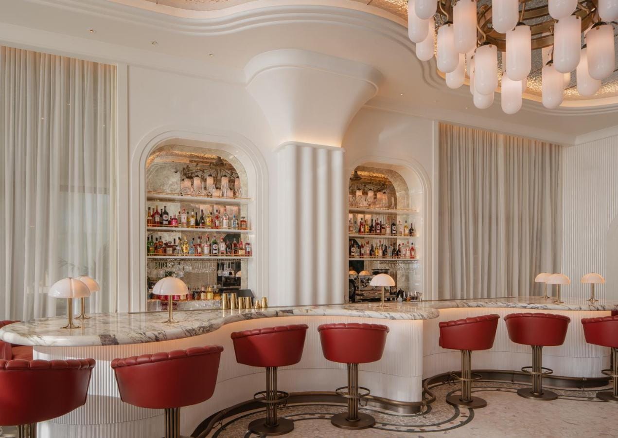 restauracja w eleganckim stylu, w beżowych odcieniach z akcentem czerwonego koloru na fotelach w four seasons resort and residences at the pearl qatar