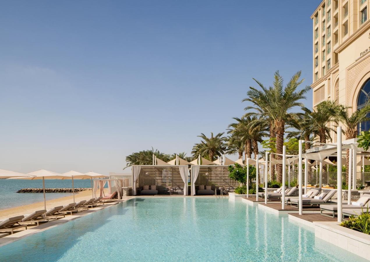 zdjęcie przedstawia basen zewnętrzny z widokiem na zatokę four seasons resort and residences at the pearl qatar