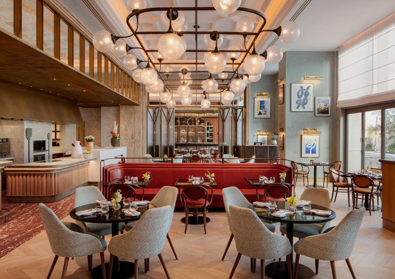 restauracja w eleganckim stylu, w beżowych odcieniach z akcentem czerwonego koloru na fotelach w four seasons resort and residences at the pearl qatar