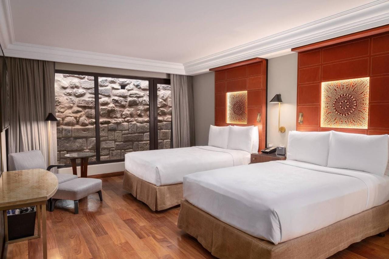 jw marriott el convento cusco przykładowa sypialnia w barwach brązu i szarości, duże osobne łóżka