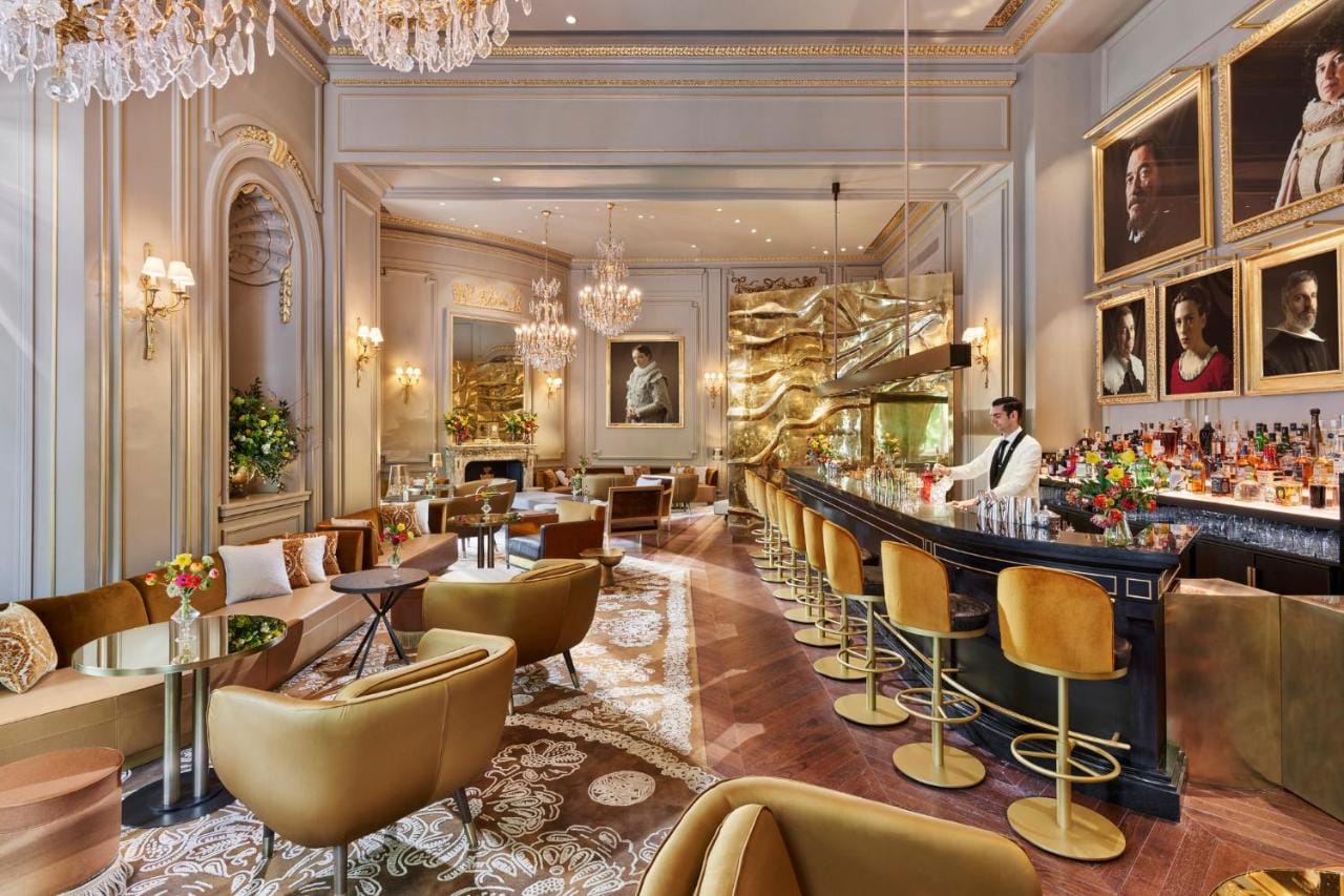 zdjęcie przedstawia bar i restaurację w hotelu mandarin oriental ritz, madrid - na zdjęciu widzimy barmana przyrządzającego napoje, wnętrze jest urządzone w stylu nowoczesnym, zachowując charakterystyczny dla Madrytu wystrój z 20 wieku