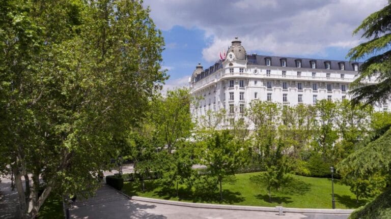 Zdjęcie przedstawia widok na budynek hotelu w otoczeniu zieleni mandarin oriental ritz, madrid