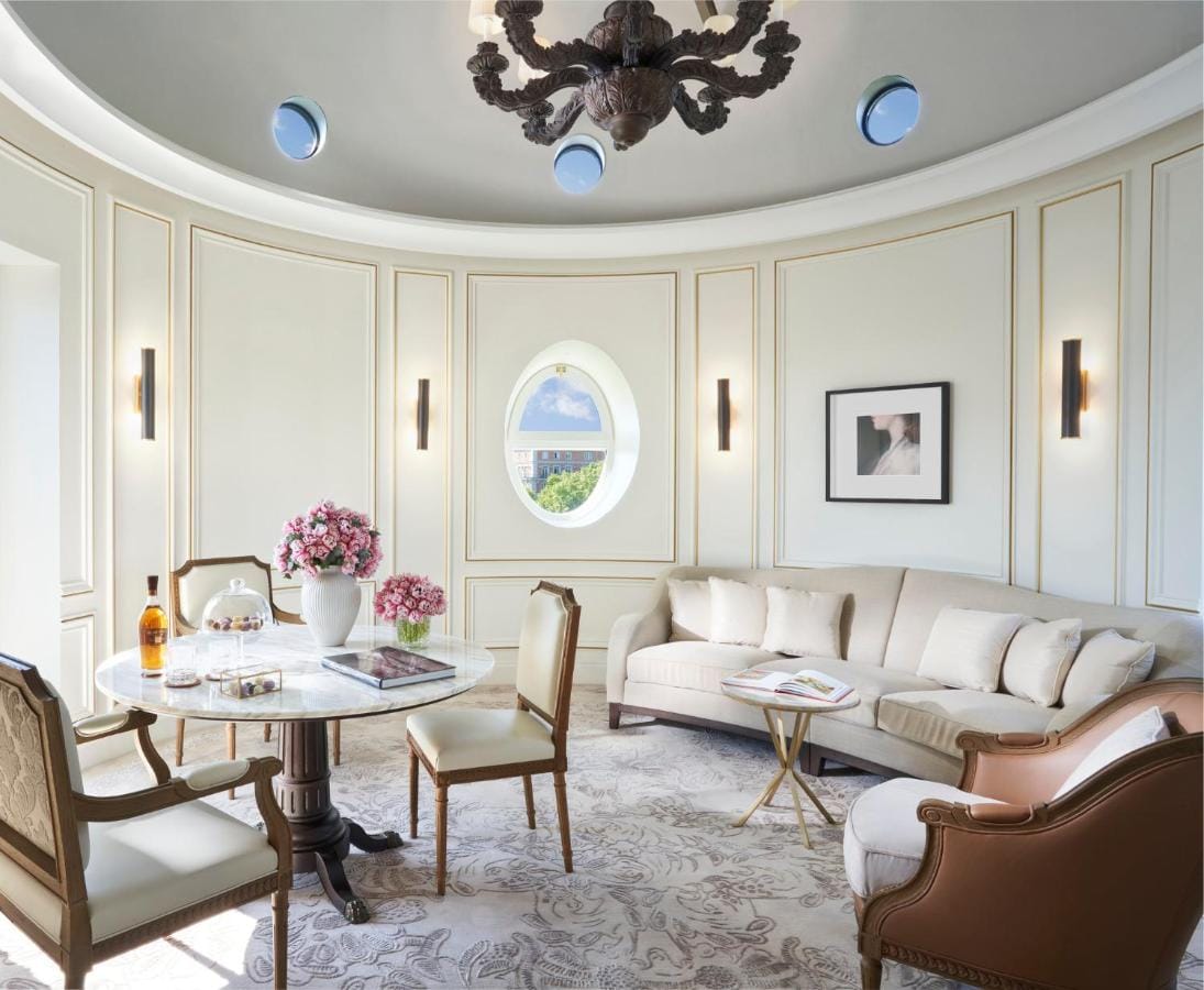 przykładowy salon apartamentu Mandarin Oriental Ritz, Madrid - w kształcie owalnym, beżowa kanapa, stół z krzesłami i fotele wypoczynkowe w jasnych odcieniach