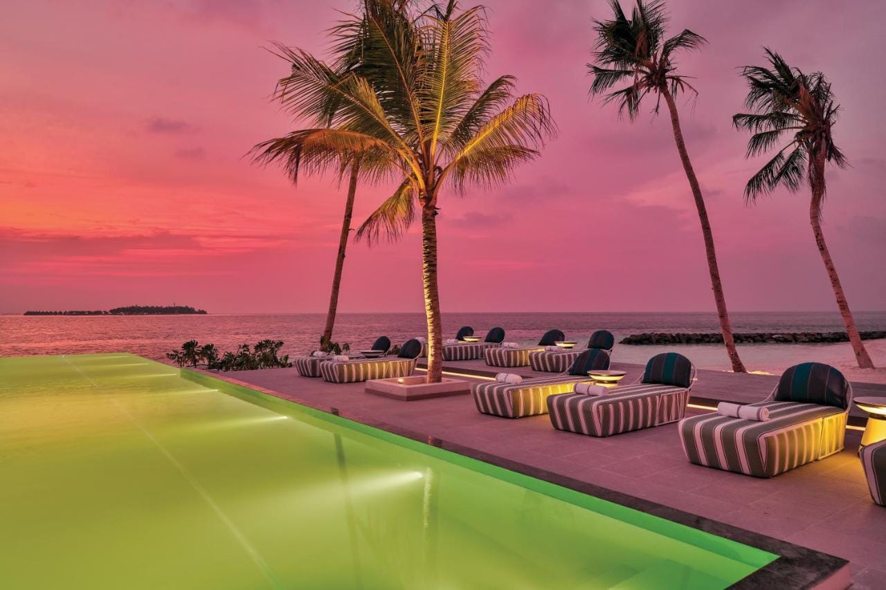 podświetlony basen z widokiem na rozległy ocean przy zachodzie słońca oblu select lobigili premium all inclusive