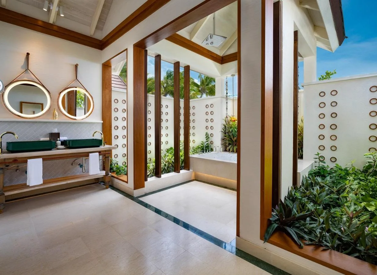 sample bathroom with water for the beach and vegetation in oblu select lobigili premium all inclusive