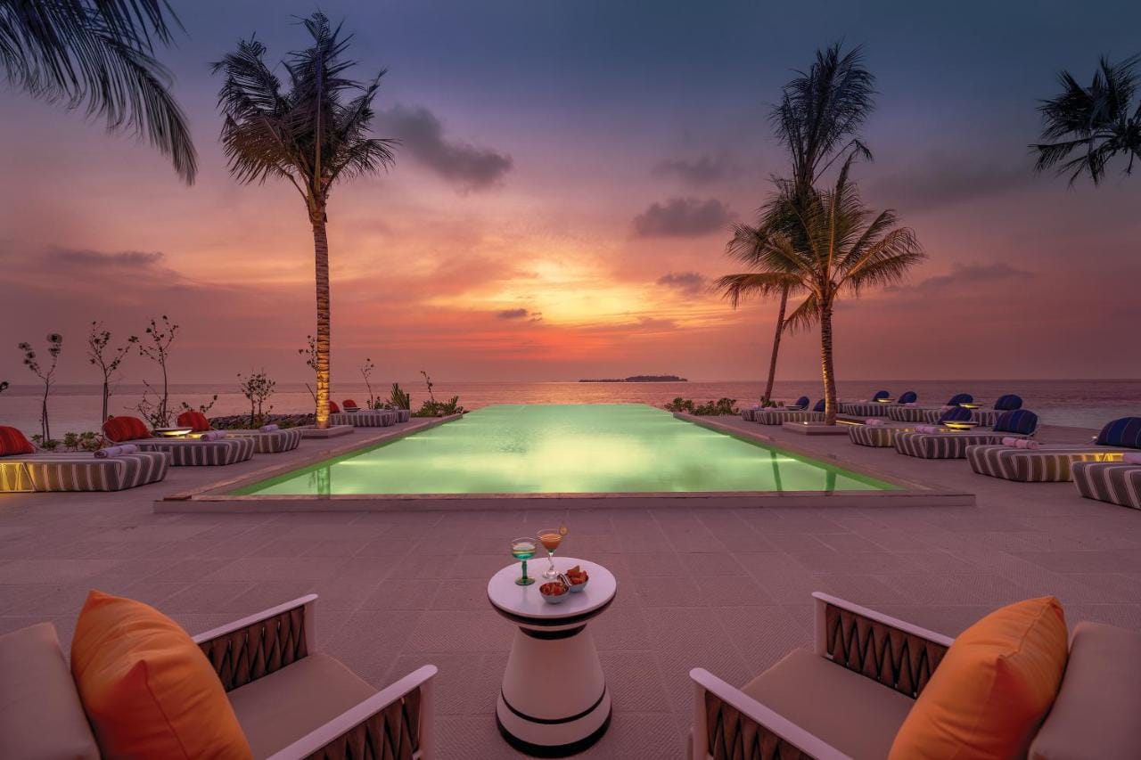 podświetlony basen z widokiem na rozległy ocean przy zachodzie słońca oblu select lobigili premium all inclusive