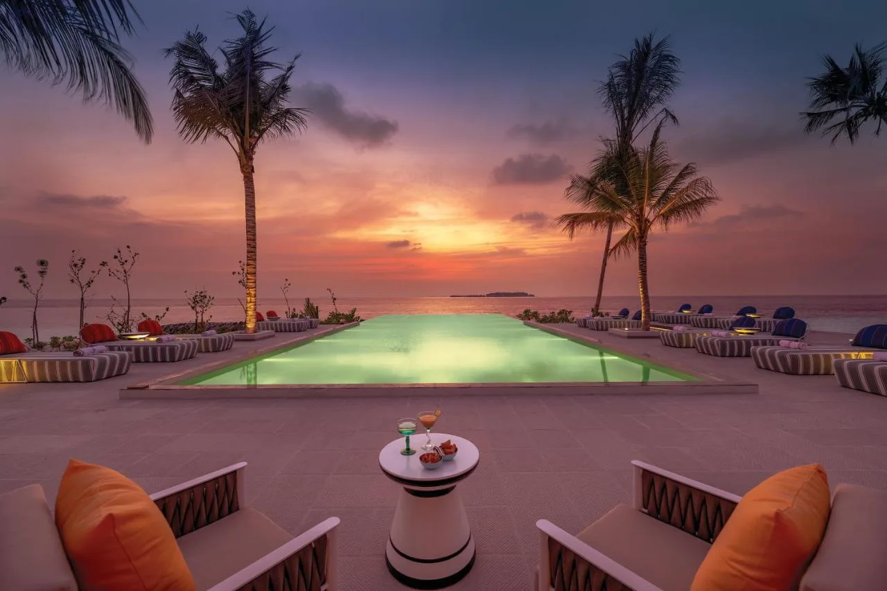 illuminated swimming pool overlooking the vast ocean at sunset oblu select lobigili premium all inclusive