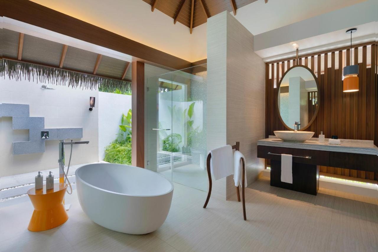 pullman maldives all inclusive resort - przykładowa łazienka z wyjściem na taras, biała duża wanna i wystrój nawiązujący do malediw