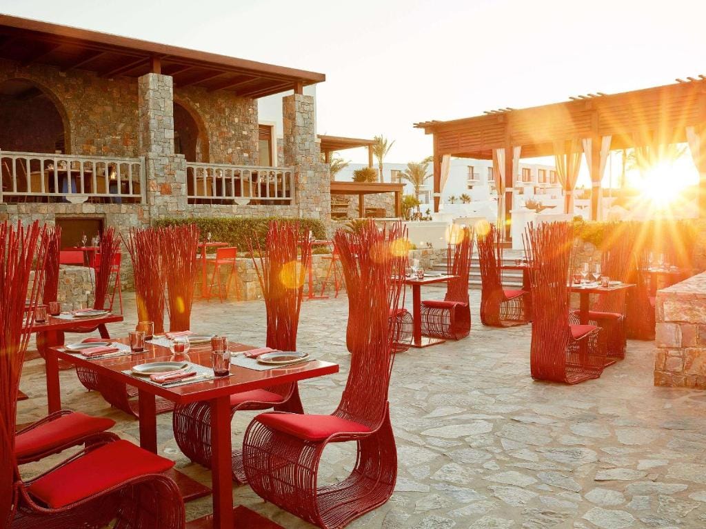 amirandes a grecotel resort to live siedzenia ciekawie wykończone w czerwonym kolorze w restauracji hotelowej na zewnątrz