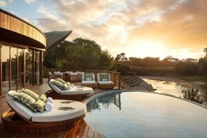 the ritz carlton masai mara safari camp leżaki nad basenem o zachodzie słońca