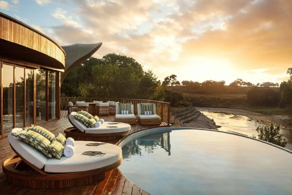 the ritz carlton masai mara safari camp leżaki nad basenem o zachodzie słońca