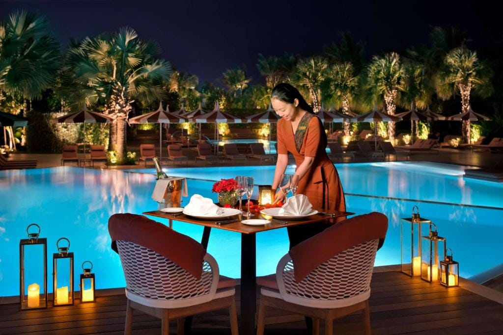 banyan tree dubai at bluewaters kobieta przygotowująca kolację dla dwojga wieczorem przy basenie